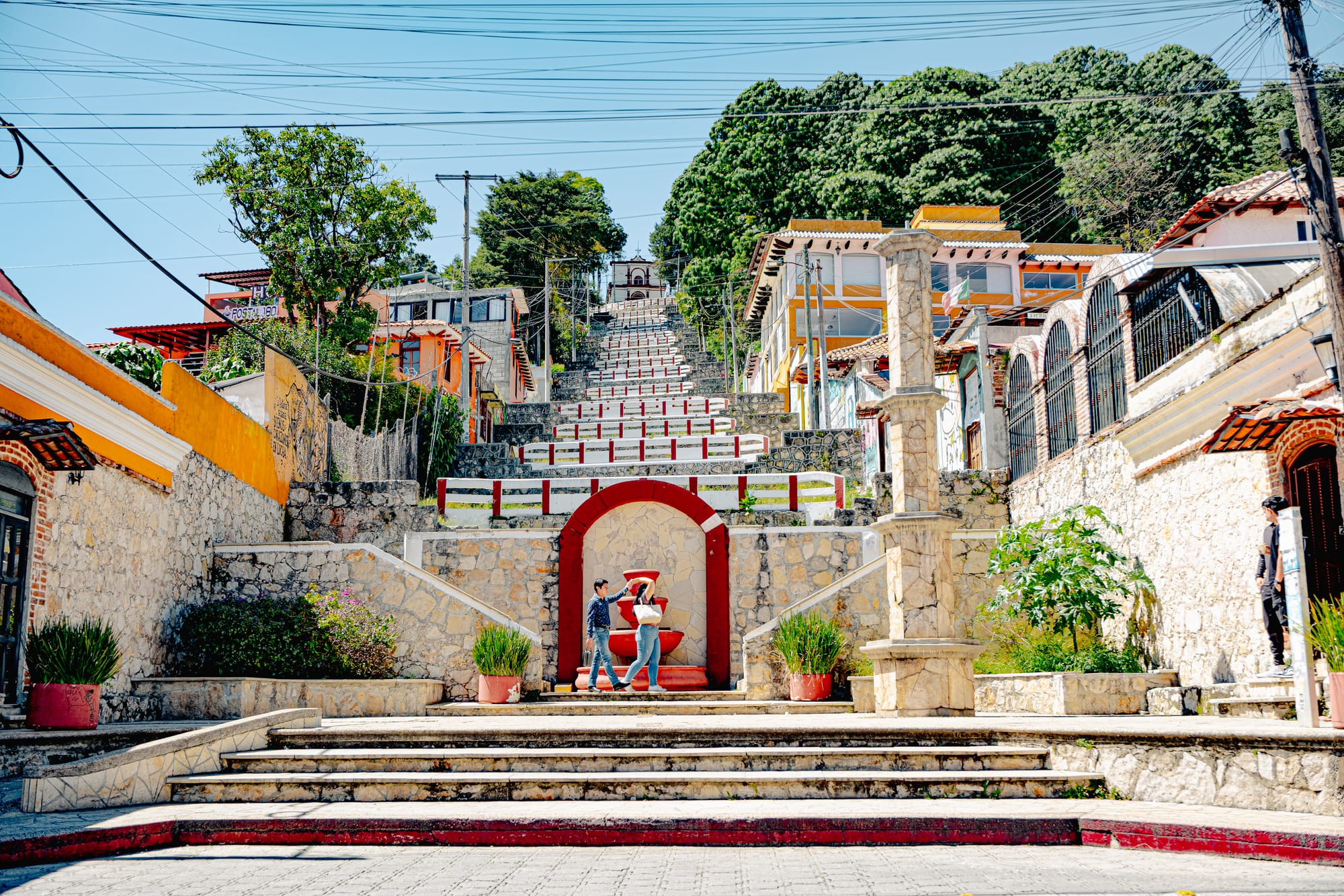 Zigzagging staircase leading up to Iglesia de San Cristóbalito in San Cristóbal de las Casas, Chiapas, Mexico, with hillside homes, street art murals, and views over the city