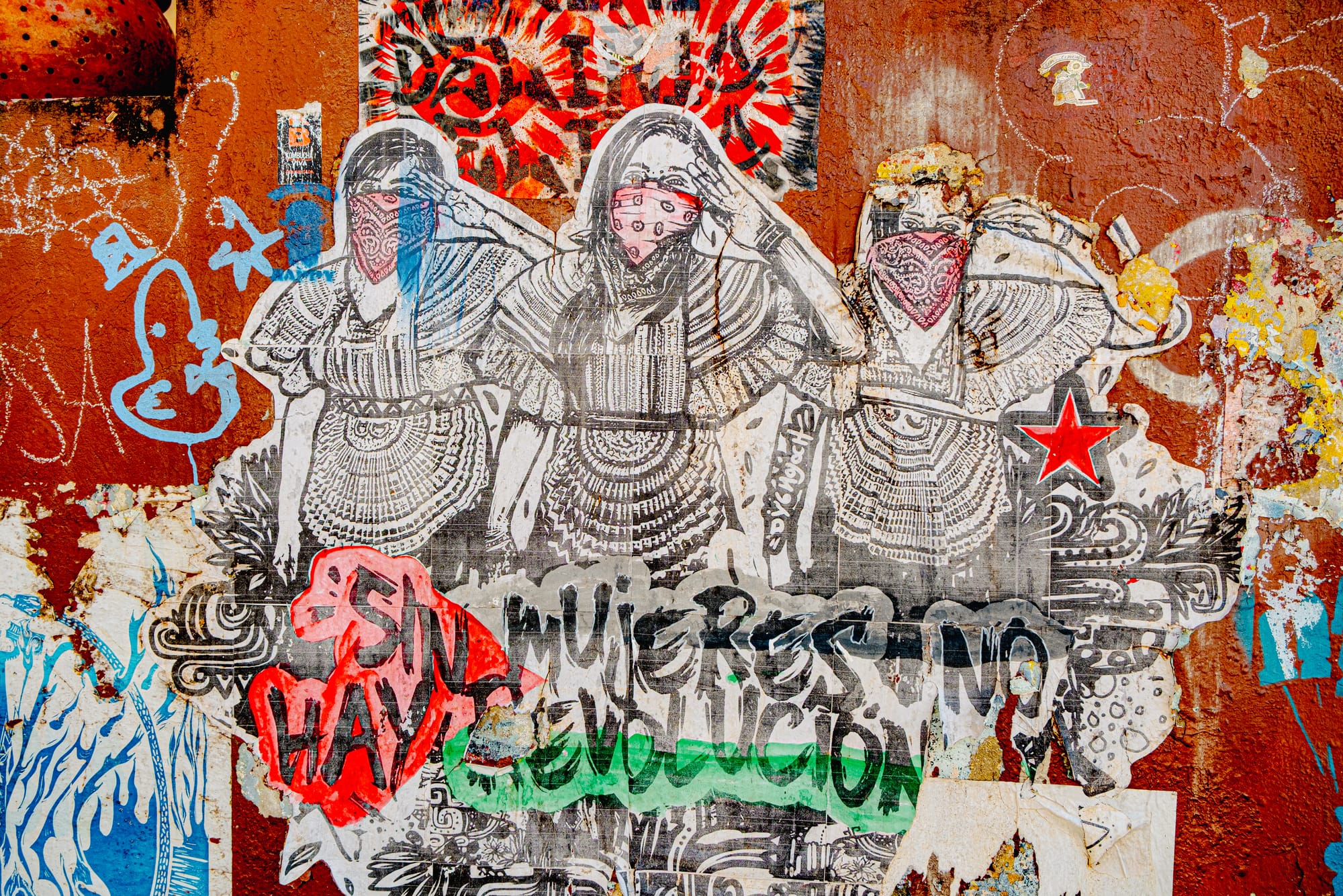 Digital nomad life in San Cristóbal de las Casas Mexico, Zapatista street art mural in the Chiapas Highlands, indigenous women wearing bandanas and red star symbol, political graffiti and autonomy movement in San Cristóbal, visible resistance culture in everyday streets, creative and political environment for digital nomads and remote workers