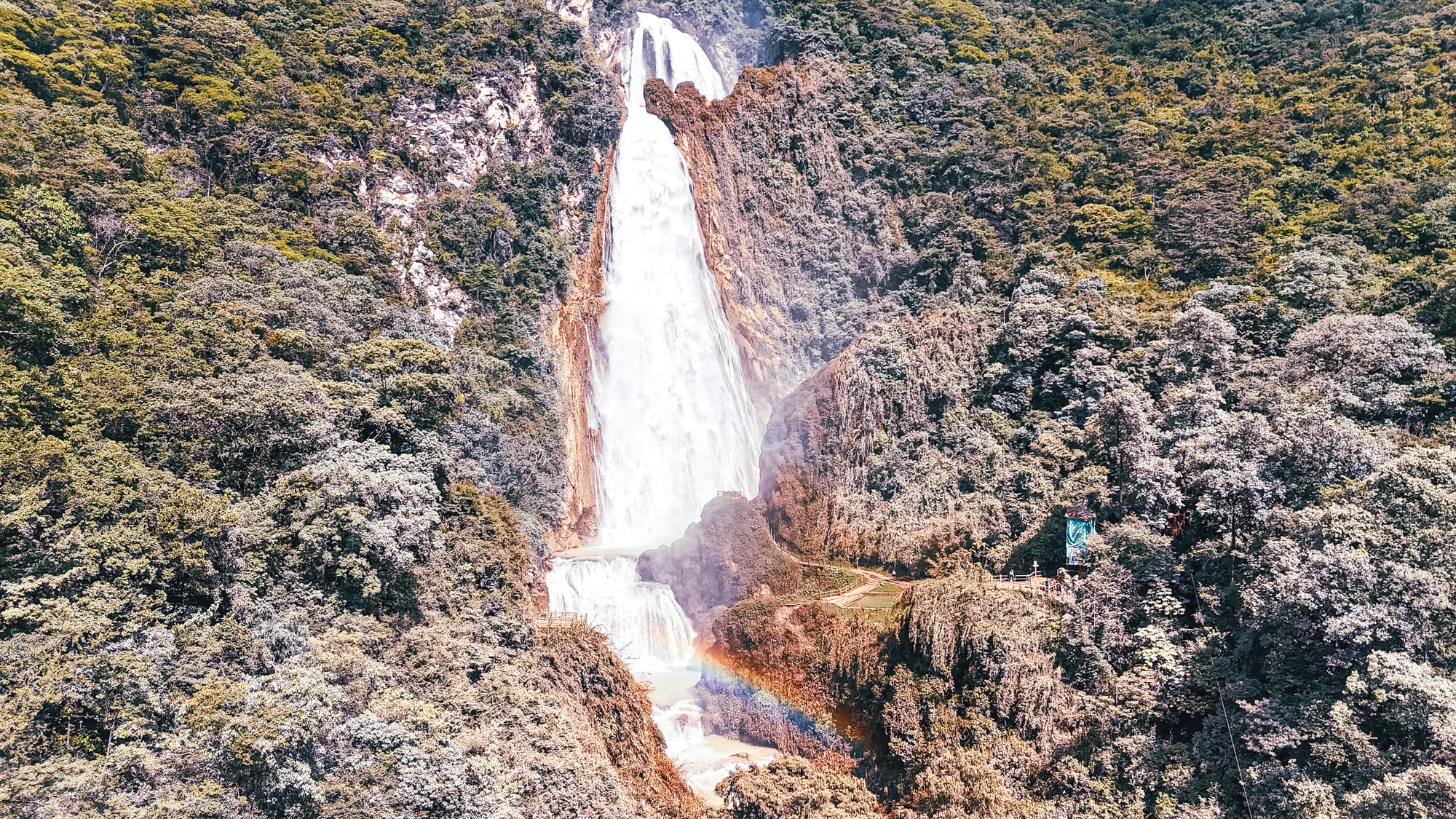 Velo de Novia waterfall at El Chiflón near San Cristóbal de Las Casas, Chiapas, Mexico, the tallest and most famous waterfall in the El Chiflón waterfall park, photographed from the main viewpoint with mist, surrounding jungle, and a visible rainbow in the spray