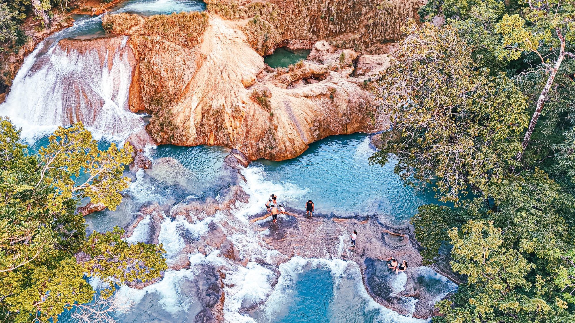 Cascadas Roberto Barrios waterfalls near Palenque, Chiapas, Mexico, stepped limestone waterfalls with multiple turquoise pools, people walking and swimming on cascades, jungle waterfalls day trip near Palenque, Roberto Barrios natural swimming pools