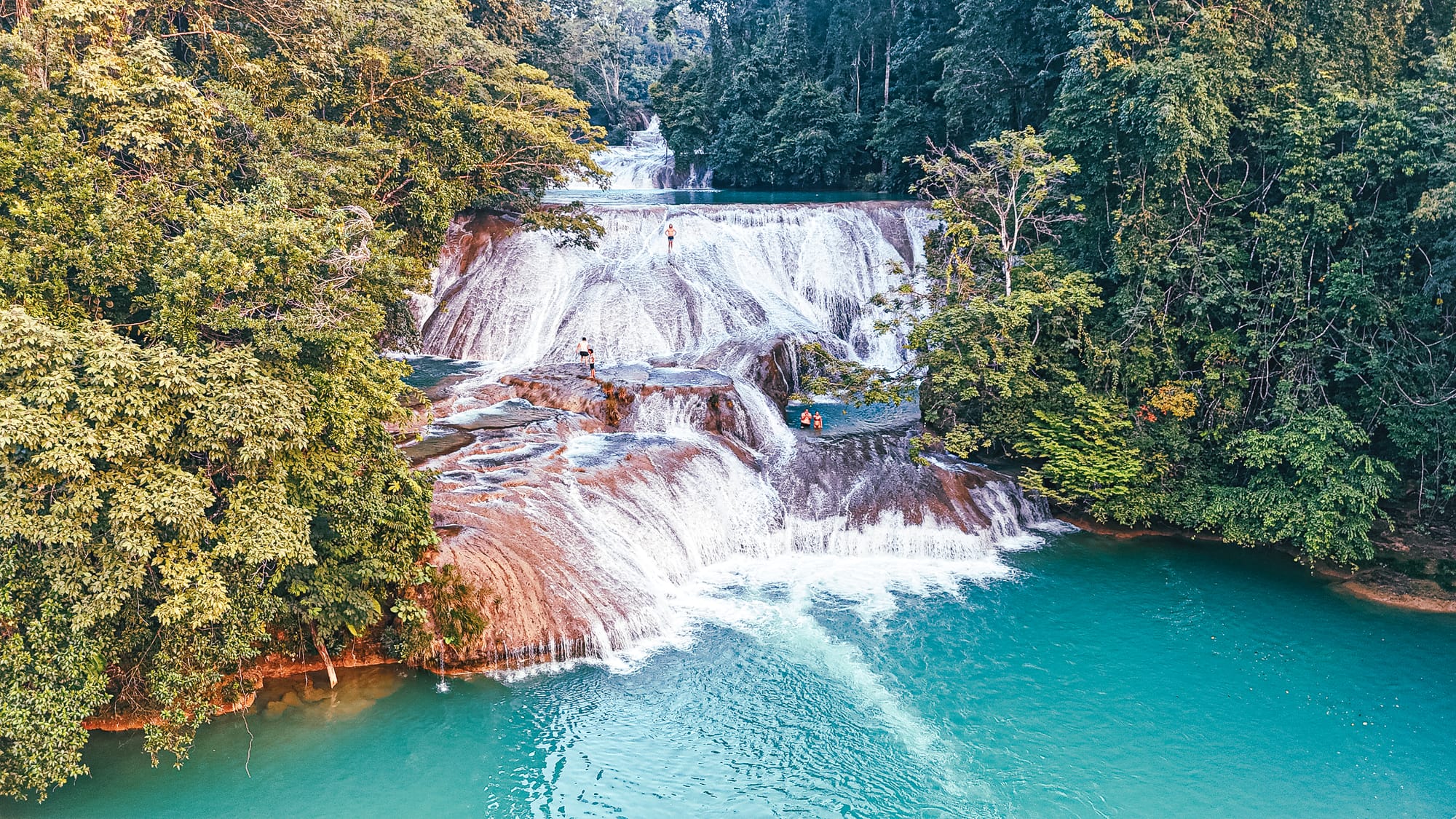 Cascadas Roberto Barrios waterfalls near Palenque, Chiapas, Mexico, wide multi tiered limestone waterfalls with turquoise pools, people swimming and standing on cascades, jungle waterfalls day trip near Palenque, Roberto Barrios natural swimming pools