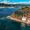 A kayaker approaches the edge of Ilhéu de Vila Franca do Campo, where a narrow concrete dock and white service building mark one of the island’s only entry points