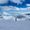 A skier stands on a snowy slope in Bansko’s Pirin Mountains, overlooking a breathtaking sea of clouds with a ski lift to the left