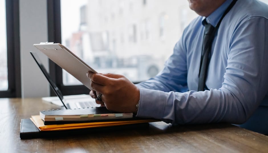 A focused professional reviewing reports at a desk.