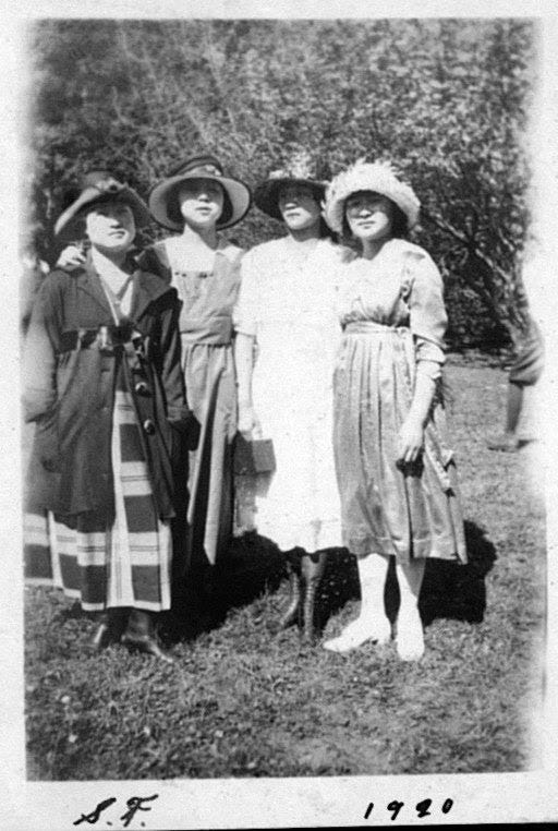 Vintage photo of four women in 1920s dresses.