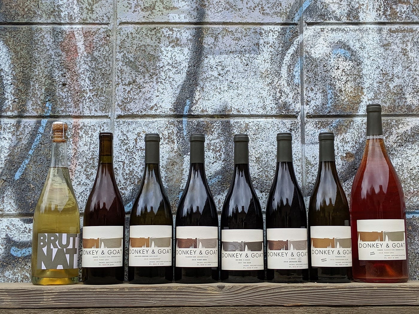 A row of wine bottles, most of them made of dark glass.
