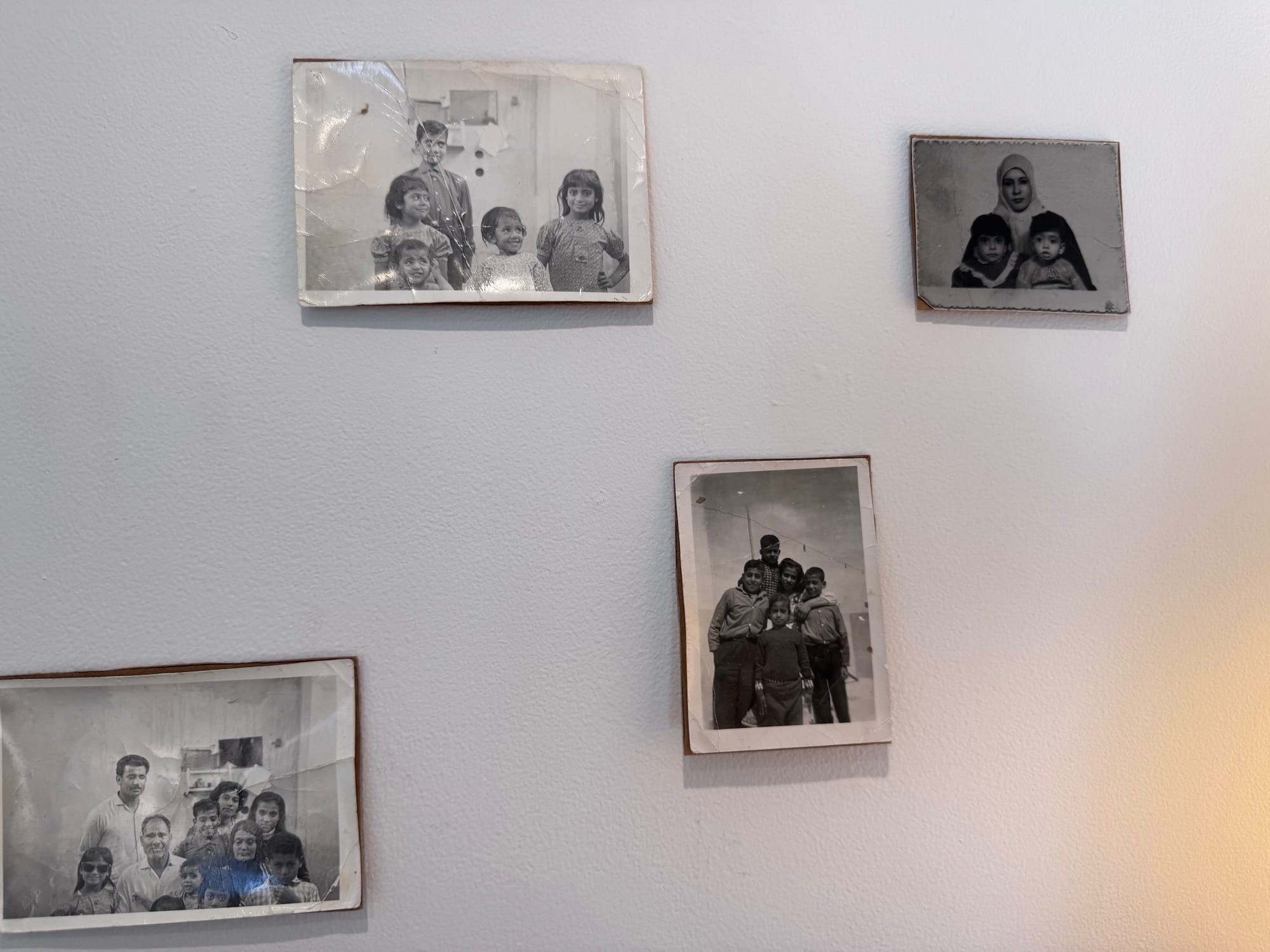 Black and white family photos displayed on a white wall