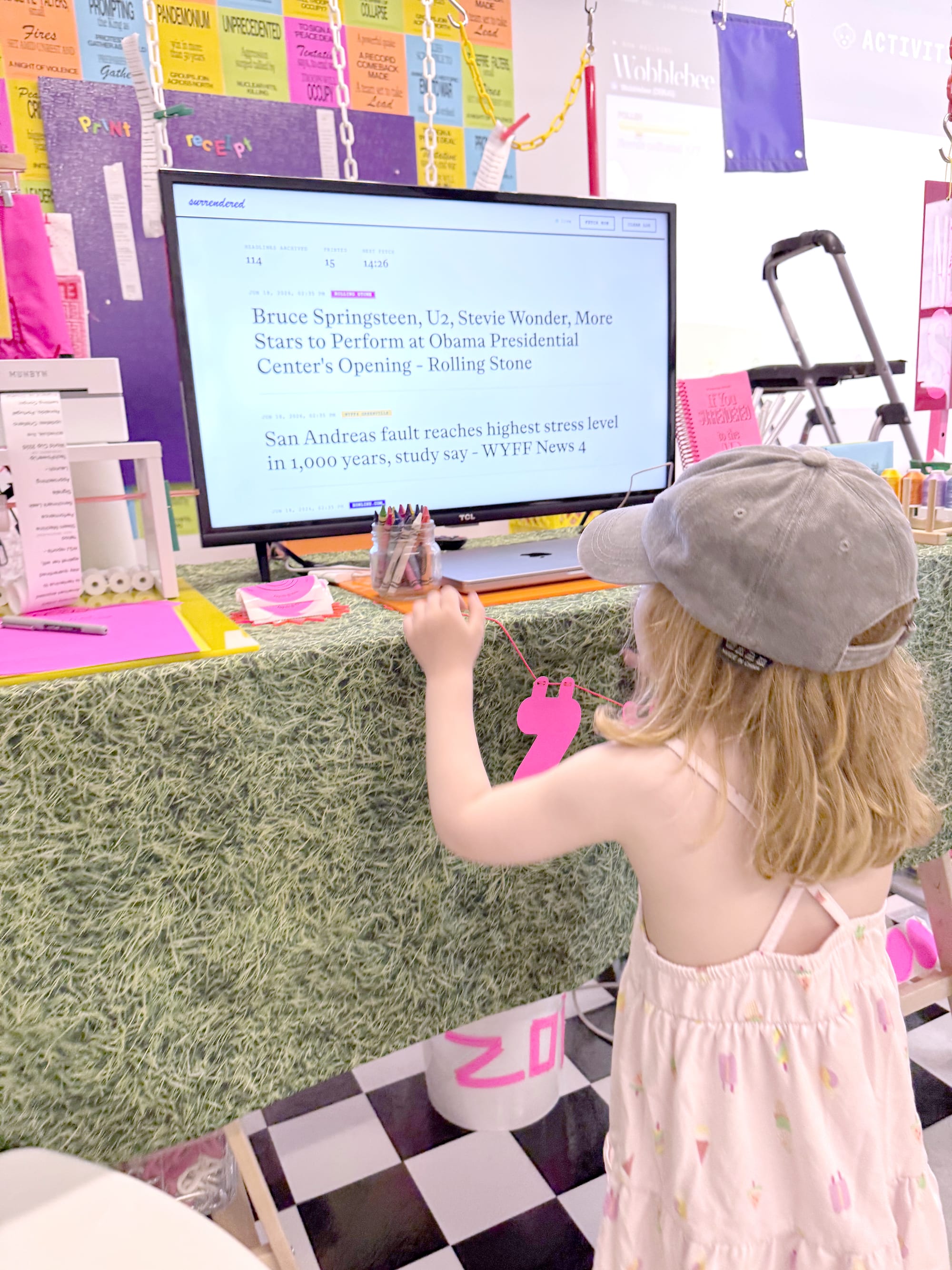 A little girl reaches for a jar with crayons at an art fair in New York City