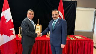 two diplomats shake hands in front of turkish cultural artifacts