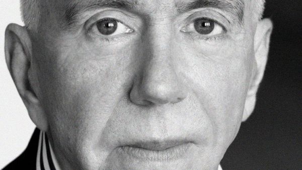 A black and white photo closely cropped to the face of a man who looks directly at the camera