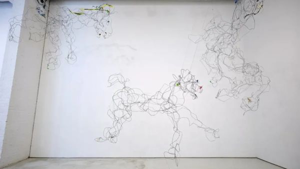 Wire sculpture of galloping horses suspended across a white gallery wall in an SVA MFA exhibition.