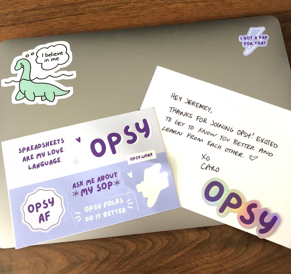 Opsy sticker sheet and thank you note from Caro on top of a member's laptop