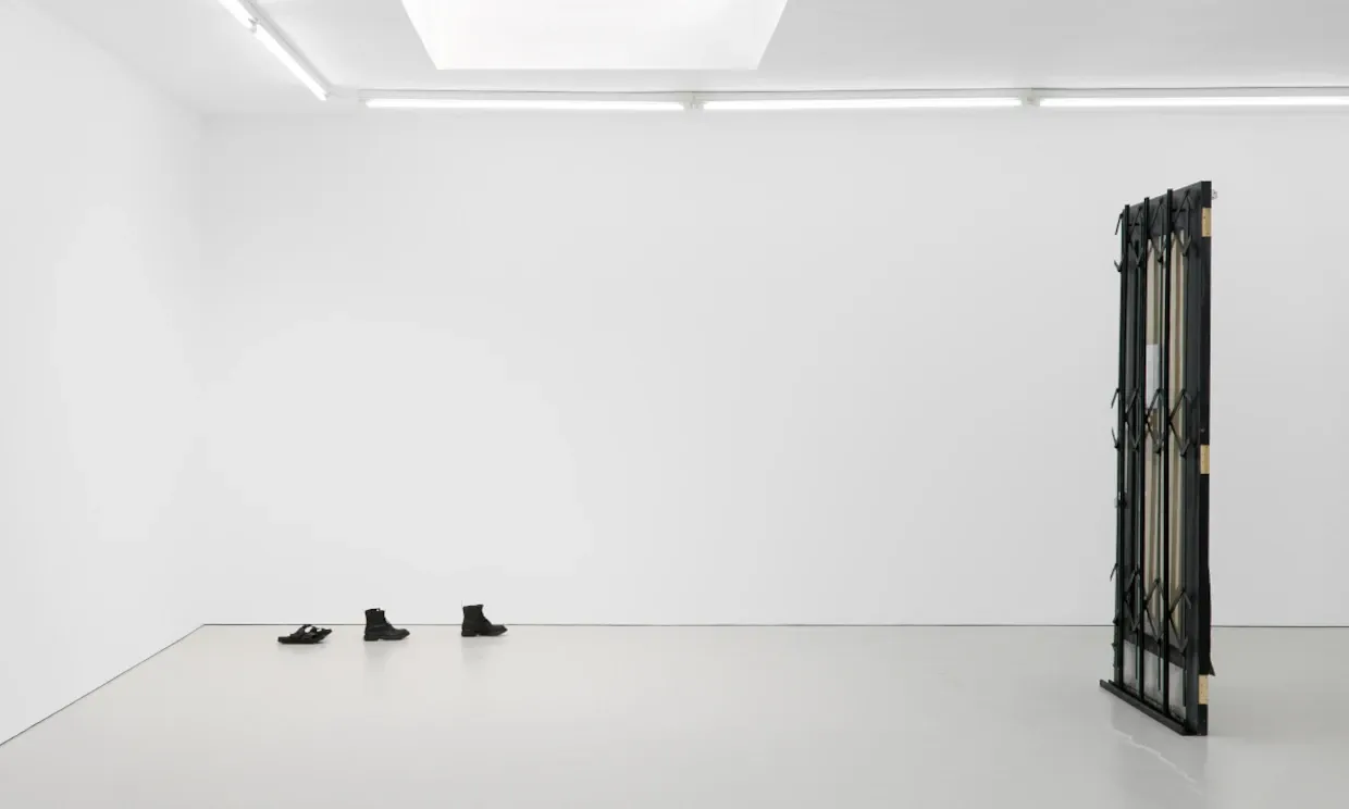 Bronze casts of shoes feature next to a door in Fiona Connor's  I haven’t arrived yet, Closed Down Clubs installation