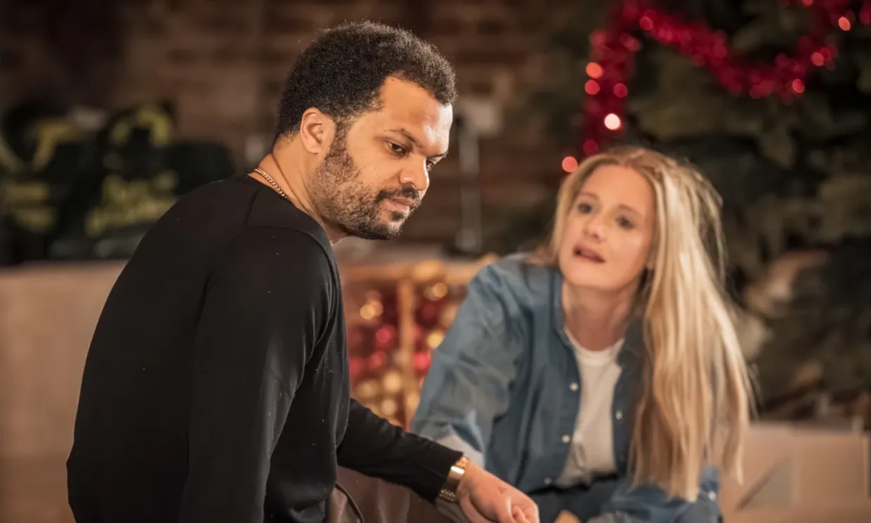 A snapshot of two actors in a scene. A man and woman appear to be having a distressing conversation.