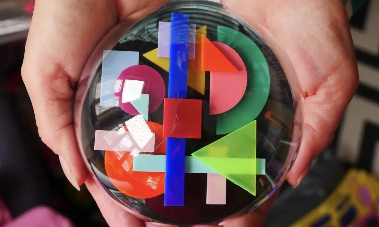 A large glass ball with colourful shapes inside. 