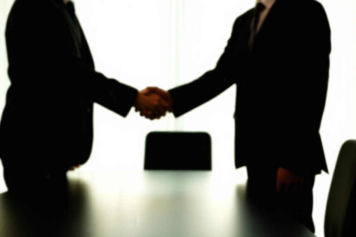 un groupe de professionnels en tenue d'affaires se serrant la main au-dessus d'une grande table de bureau moderne, éclairage naturel doux