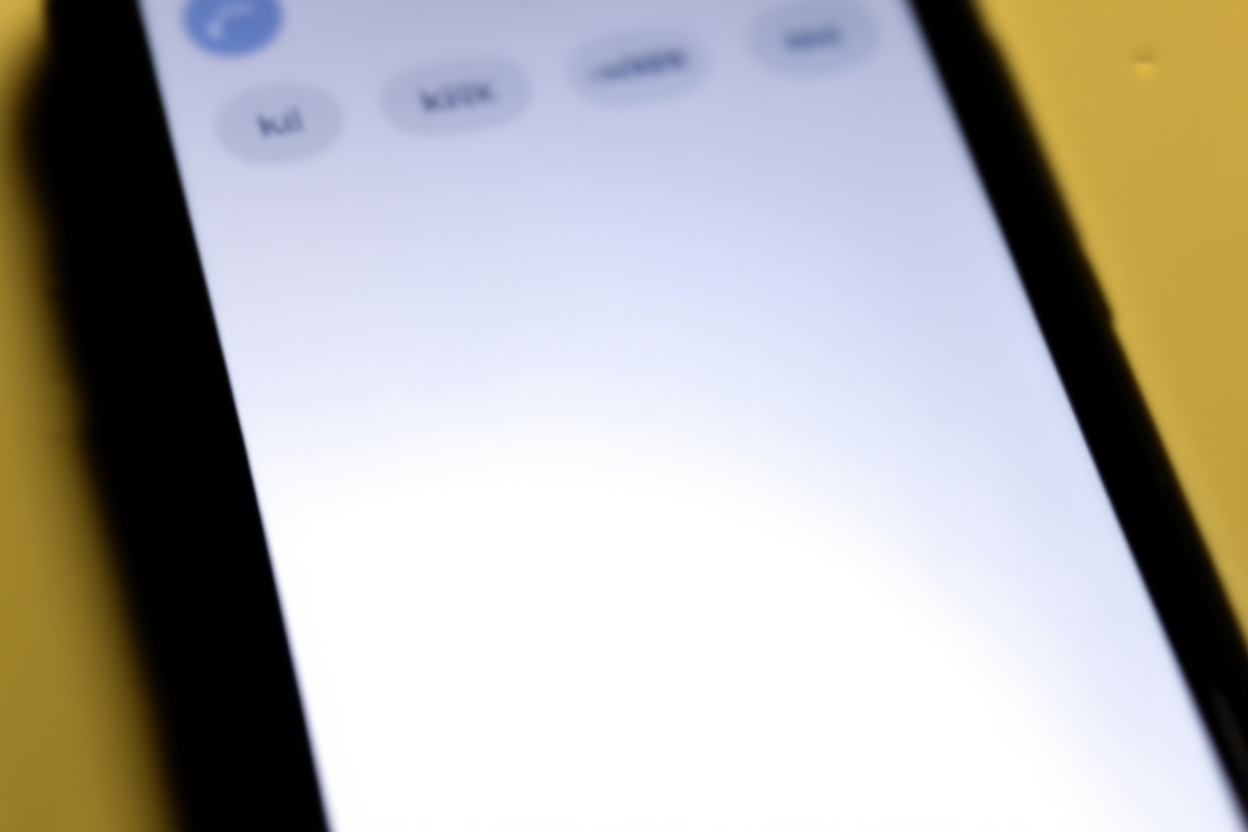 sebuah smartphone yang menampilkan antarmuka aplikasi dengan kata kunci, cahaya siang lembut, bidikan lanskap lebar