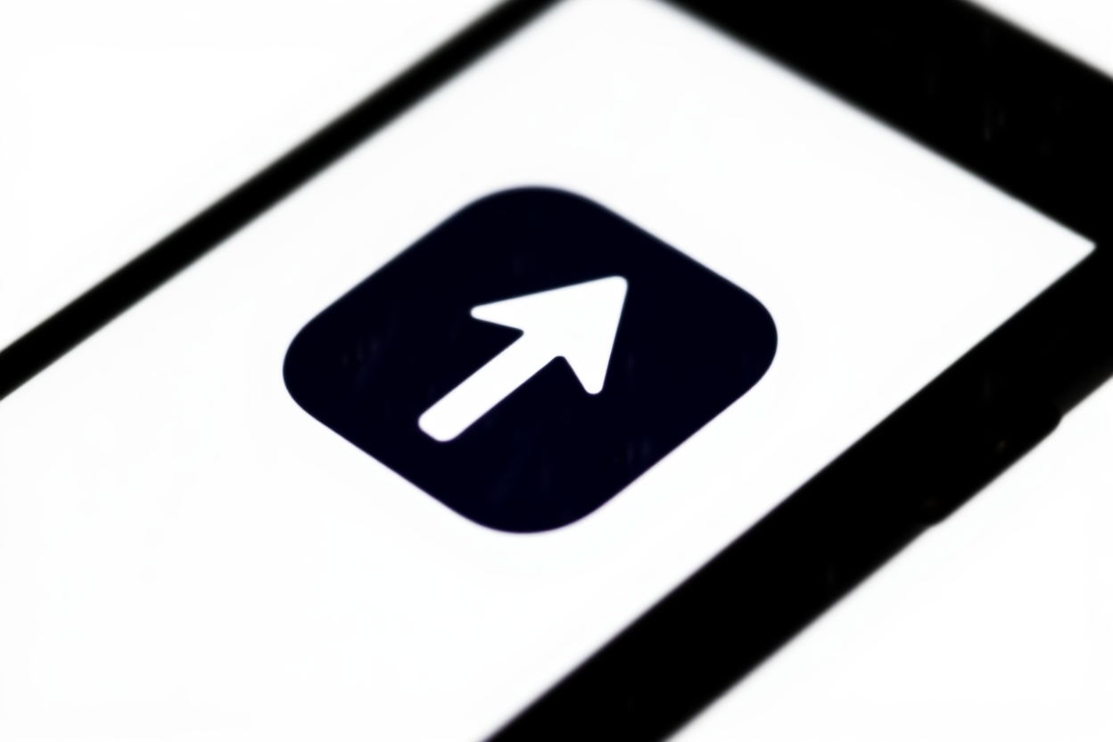 ein Smartphone, das eine App-Symbol mit einem aufwärts gerichteten Pfeil auf einem sauberen weißen Hintergrund anzeigt, was automatisierten Upload symbolisiert