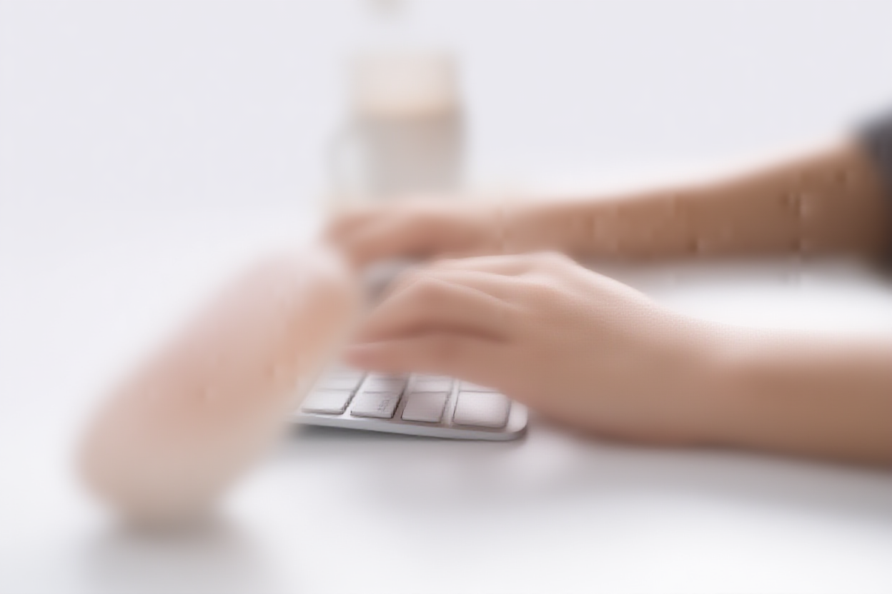 Eine Person tippt auf einer schlichten Laptop-Tastatur mit Kaffeetasse in der Nähe in einem modernen Büro\