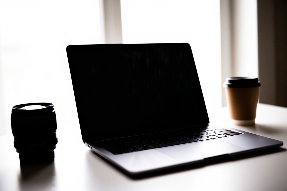 Professioneller Fotograf prüft Metadaten auf dem Laptop-Bildschirm mit Stock-Agentur-Logos im Hintergrund