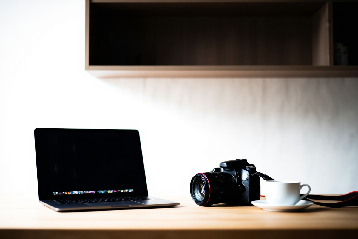 Ein professioneller Fotograf überprüft Metadaten auf einem Laptop-Bildschirm in einer hellen Studio-Umgebung
