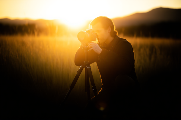 Eine Nahaufnahme eines Fotografen, der ein gedrucktes Stock-Foto hält und die Details unter natürlichem Sonnenlicht mit einem unscharfen Studiohintergrund untersucht