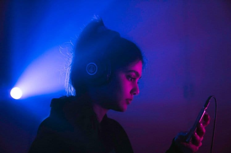 Man using a phone in low light, representing Spotify's competitive impact on audiobooks
