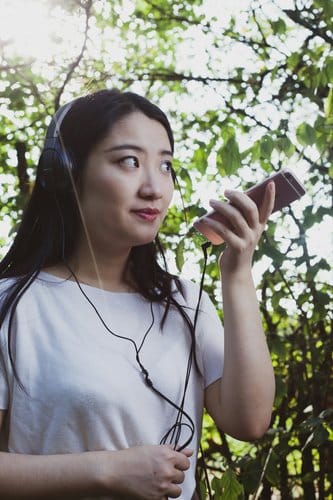 Woman holding a smartphone, representing audiobook catalog browsing