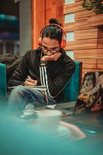 Man sitting and listening to an audiobook or book summary through headphones