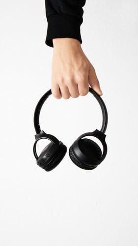 Person holding wireless headphones, ready to start an audiobook free trial