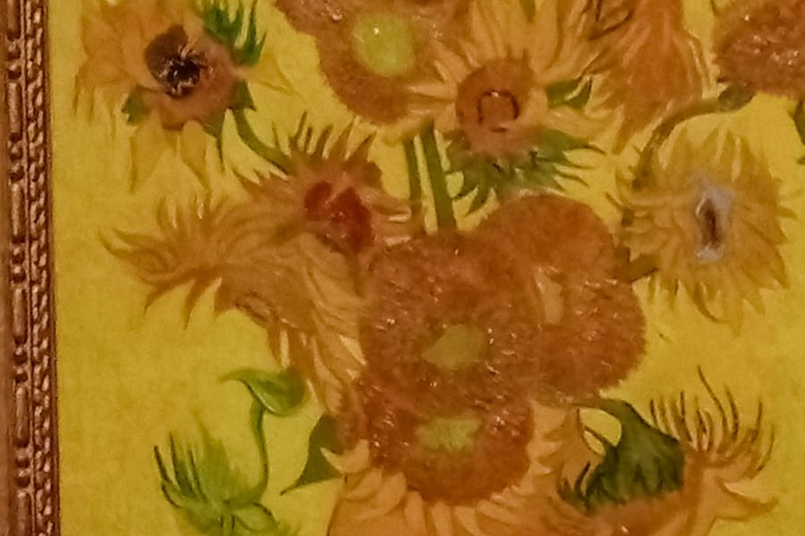 Still life of sunflowers by Vincent van Gogh, vibrant yellow tones and dynamic brushstrokes conveying energy and life.
