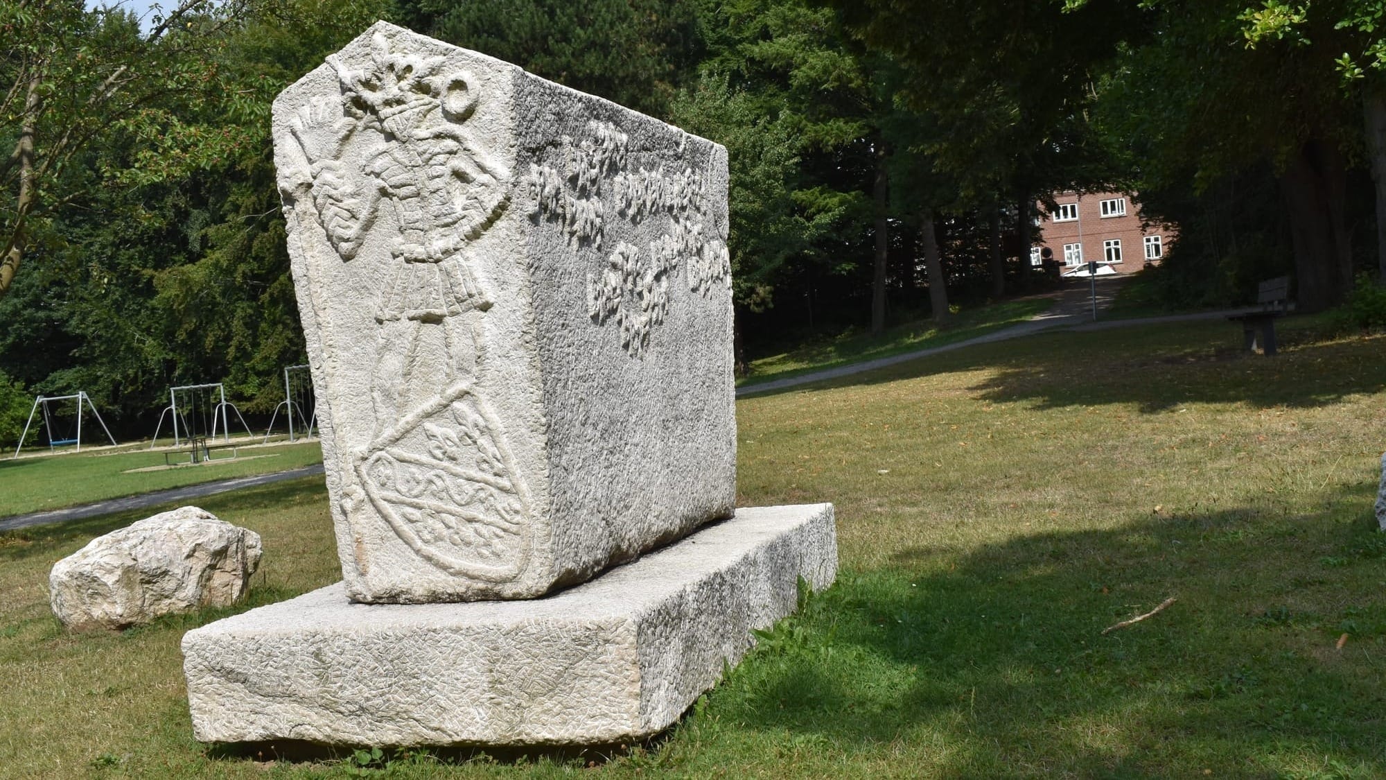 ’Bosnisk-Hercegovinsk-Dansk Stećak’ i Sankt Jørgens Park i Odense. I baggrunden kan Jomsborgvej skimtes mellem træerne. Den bosniske bjerglilje, der sjældent findes uden for Bosnien, pryder ’gavlen’, mens noget så odenseansk som et H.C. Andersen-citat pryder langsiden: ”Leve er ikke nok! Sagde han, ”Solskin, Frihed og en lille Blomst maa man have!”. På modsatte gavl hilser en skikkelse pænt på beskueren. Motivet er inspireret af Radimlja i Hercegovina. For skikkelsens fødder ligger et bosnisk skjold og et nedlagt spyd som symbol på fred. På den anden langside er der et citat fra digtet ’Modra rijeka – Blå flod’: ”… Over trætte, over bitre. Over tjørn, over tornbusk. Over hede og over hindring. Over forudanelse og over tvivl…” Mehmedalija ”Mak” Dizdar, der var fra Stolac, skrev digtet i 1960’erne og rammer den lidelse og tragedie, som de bosniske flygtninge har overlevet, men også det de fandt og fik i Danmark. (Jimmy Munk Larsen)