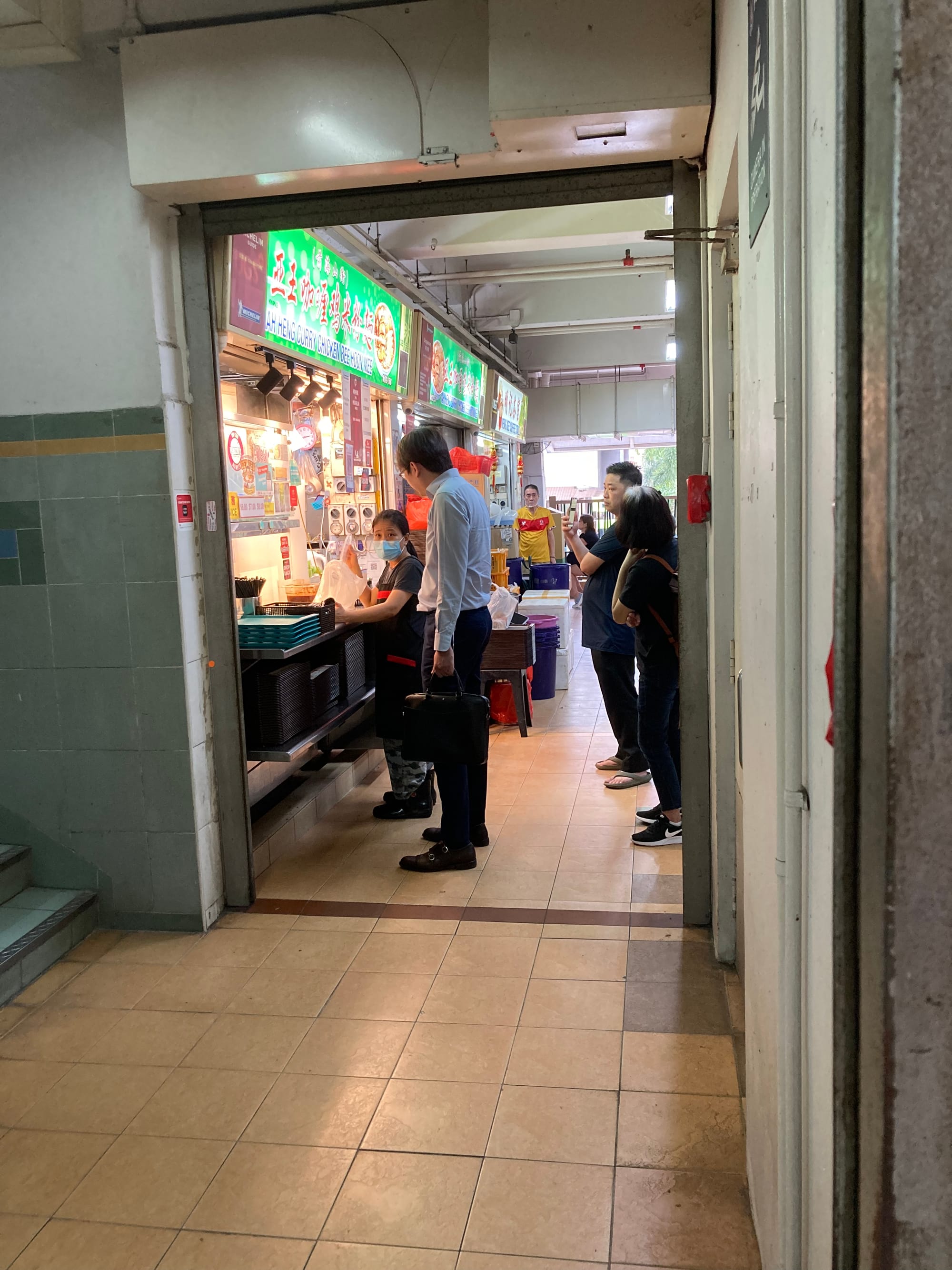 An office worker orders his meal at a stall in a food centre