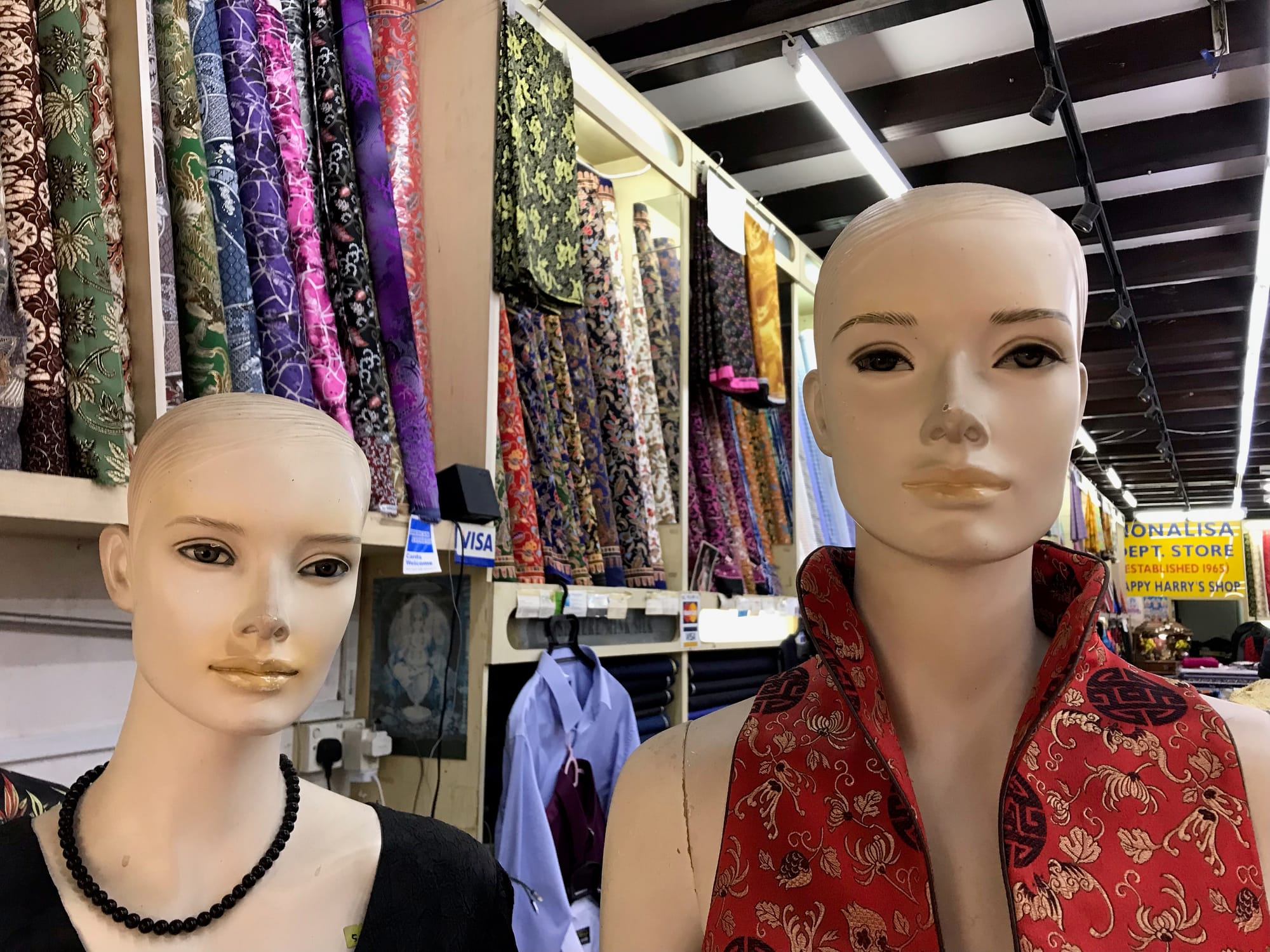 Two female mannequins in a dress fabric shop.