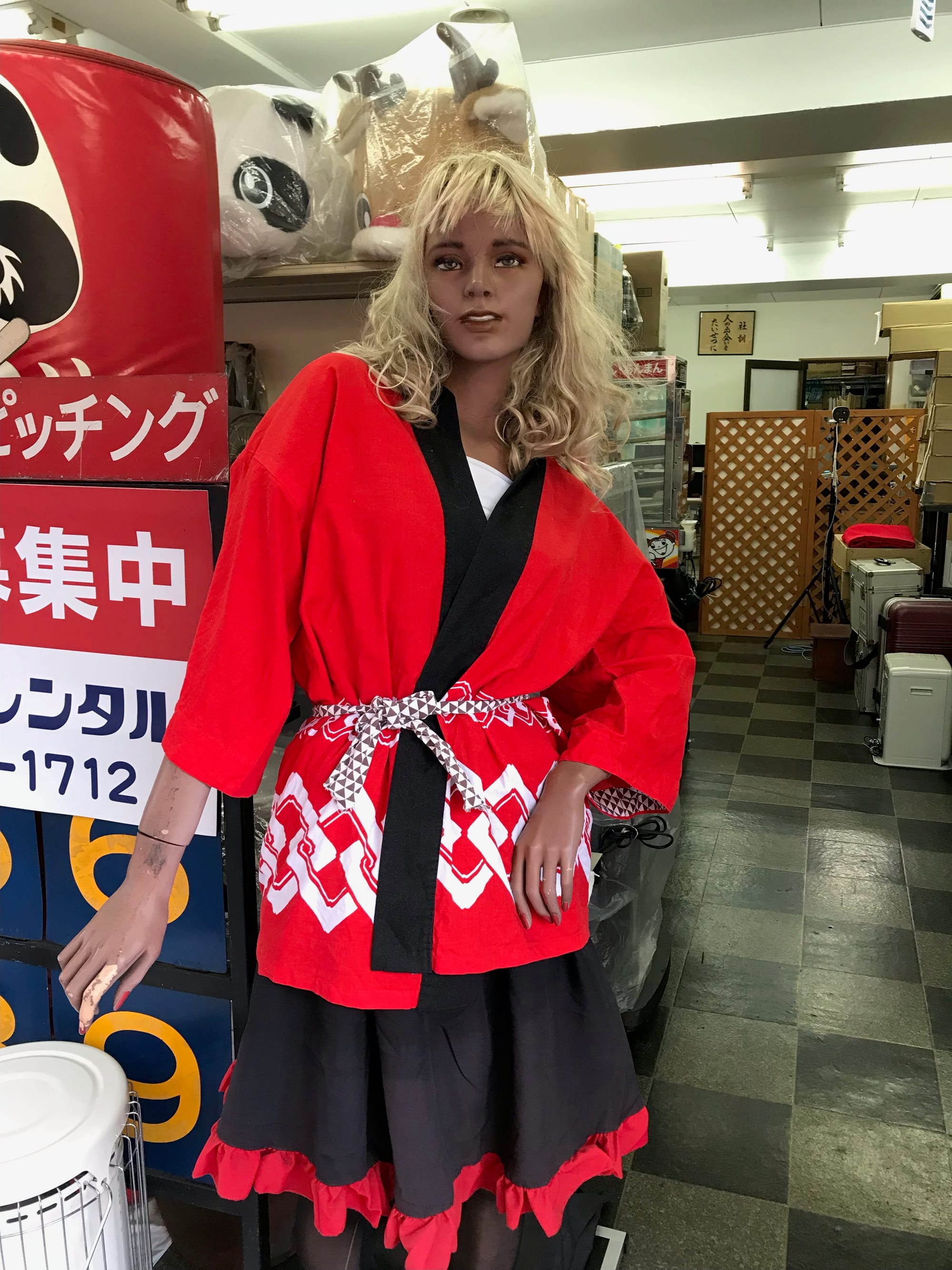 A female mannequin with blonde hair wears a red, black, and white yukata.