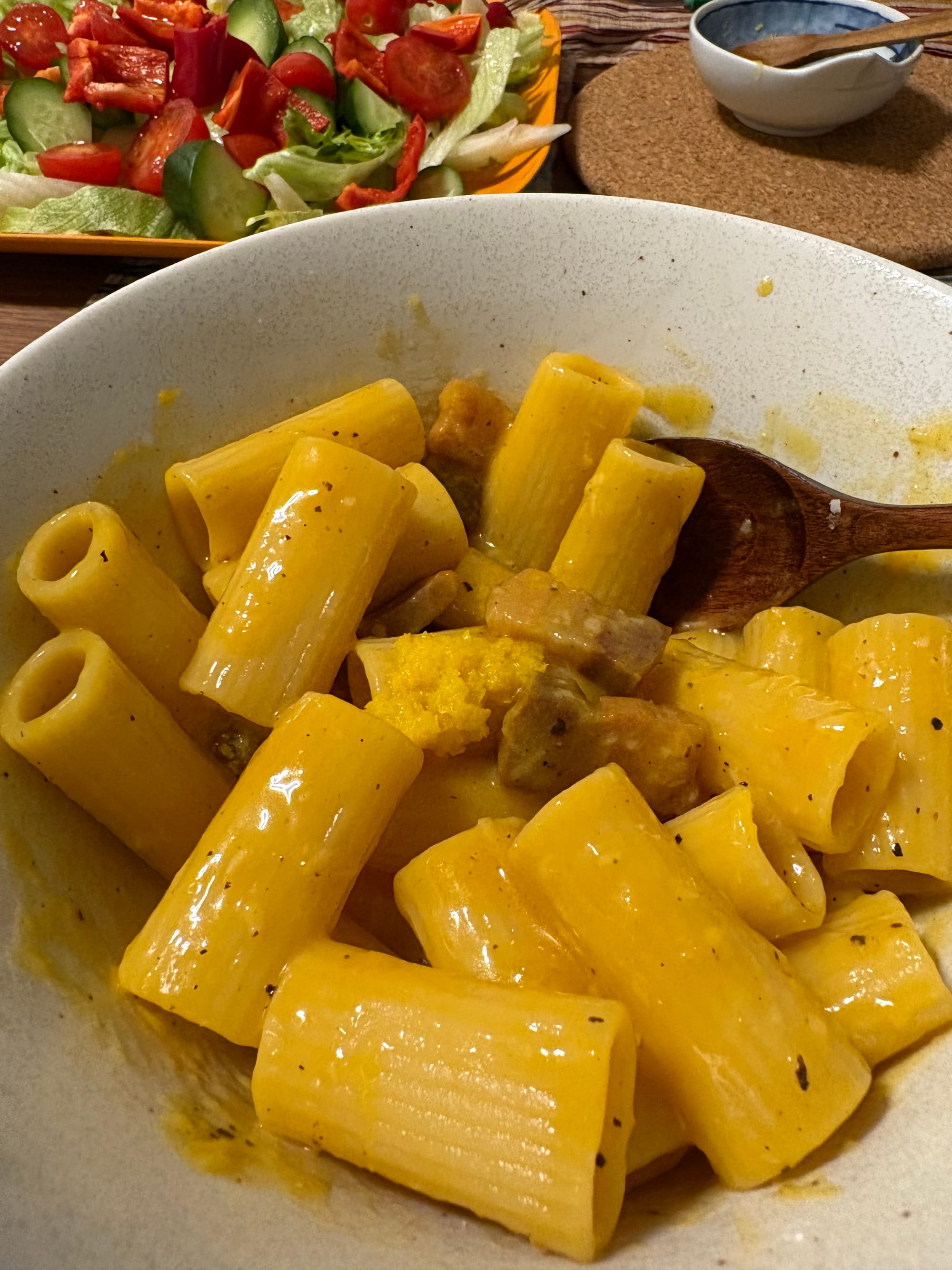 A clump of yuzu peel in the middle of a carbonara rigatoni