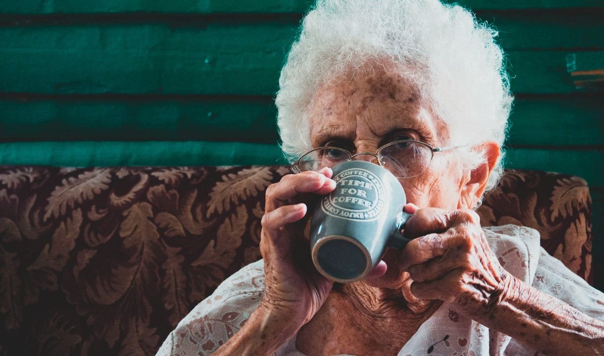 old white woman with dementia and dysphagia drinking tea 