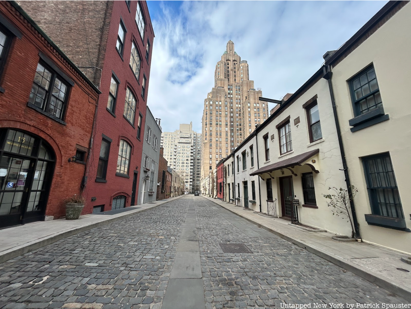 A cobblestone street bounded by low houses that is part of the Washington Mews private street