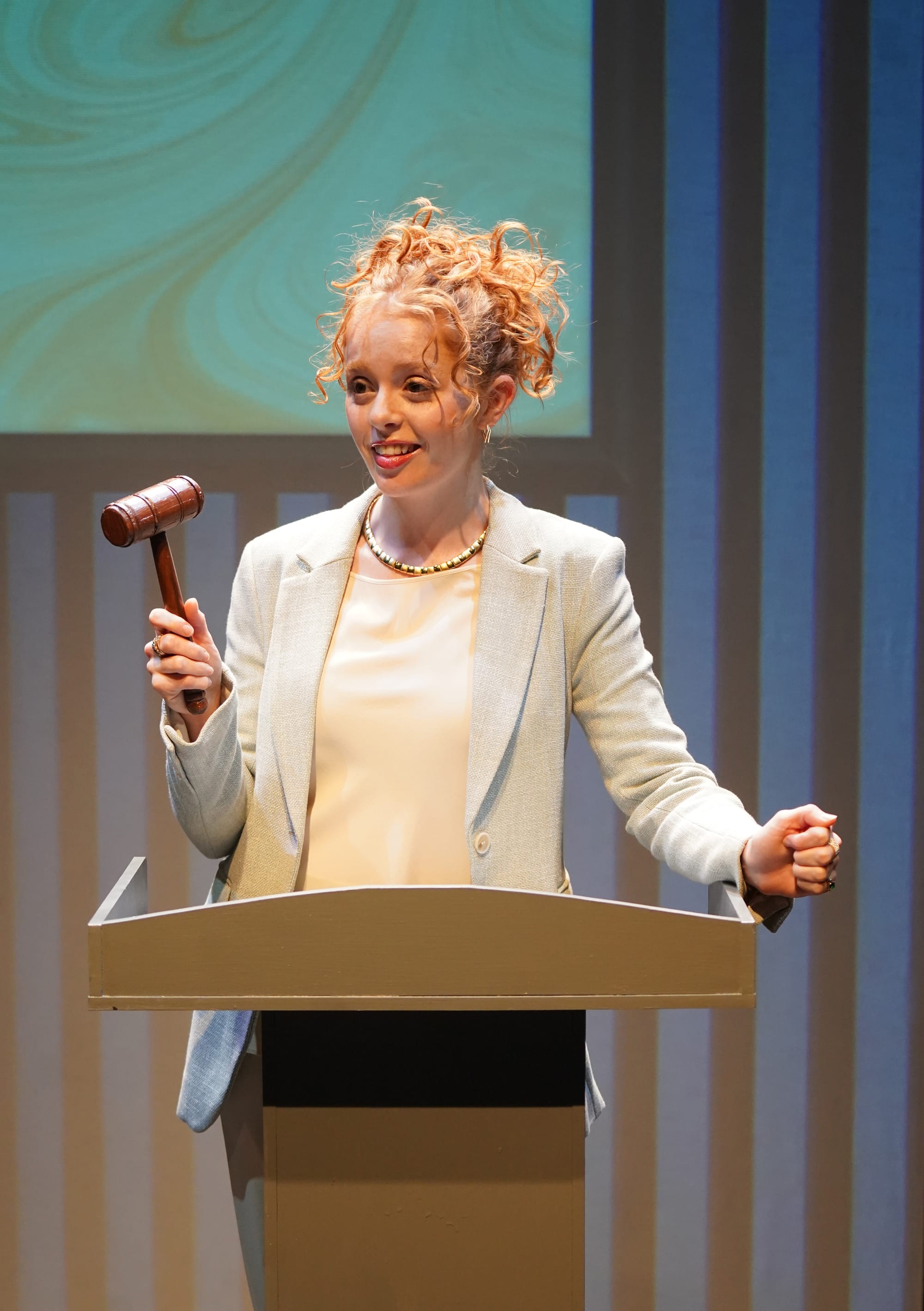 Caroline Portante wielding a gavel at a co-op board meeting. Photo credit: Carol Rosegg