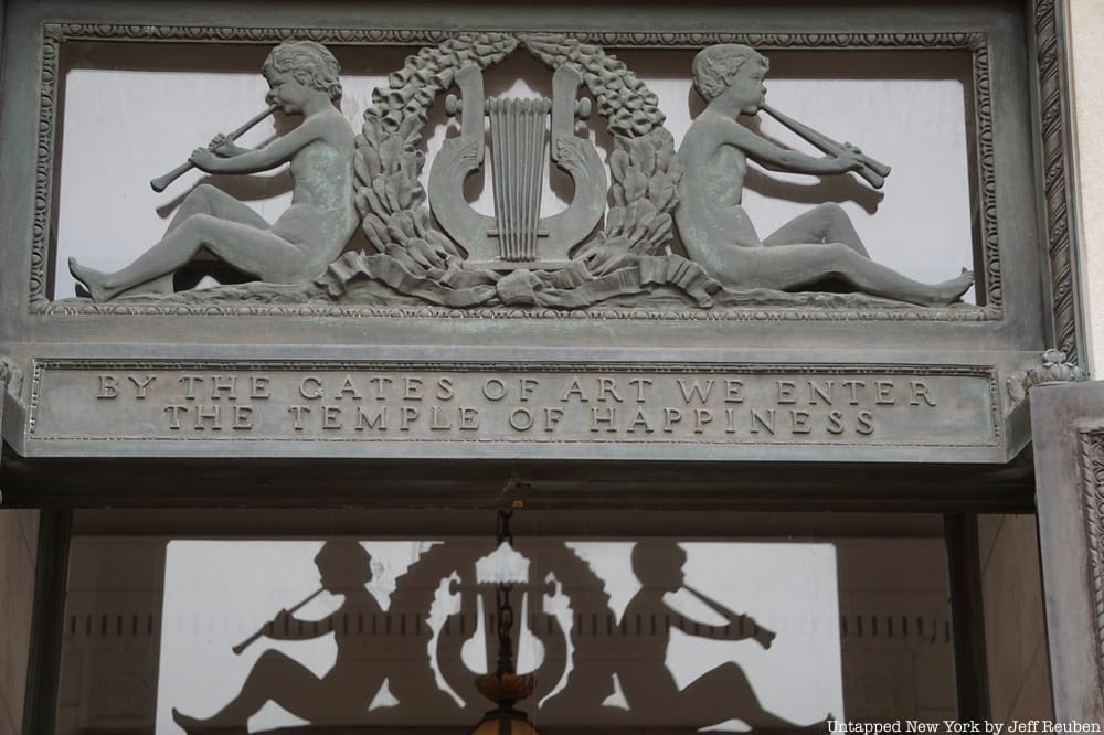 Inscription above the door which reads: "By the gates of art we enter the temple of happiness"