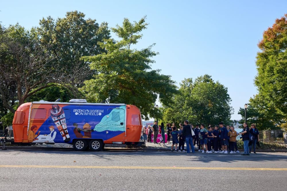 People lined up outside the museum on wheels Airstream