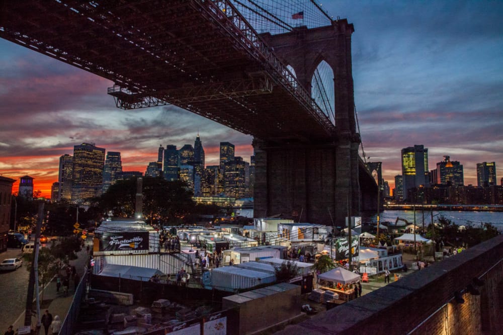 Photoville shipping container galleries below the Brooklyn Bridge