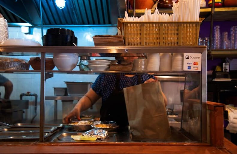 Woman packing food to go in a restaurant