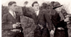 Black and white photo of three men standing ready for attack, two with a gun and one with a grenade in his hand