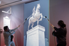 Museum visitors pulling ropes in interactive exhibit simulating the toppling of King George III equestrian statue, Revolutionary War history display