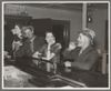 Black and white photo of two men and two women drinking at a bar