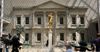 A gold statue stands at the center of the American Wing at the Metropolitan Museum of Art