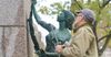 Man makes repairs to a bronze female sculpture