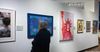A woman looks at a wall of art at the heller Museum