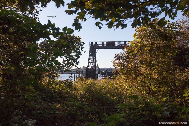 An airplane takes off from nearby LaGuardia airport with a gantry crane in view.